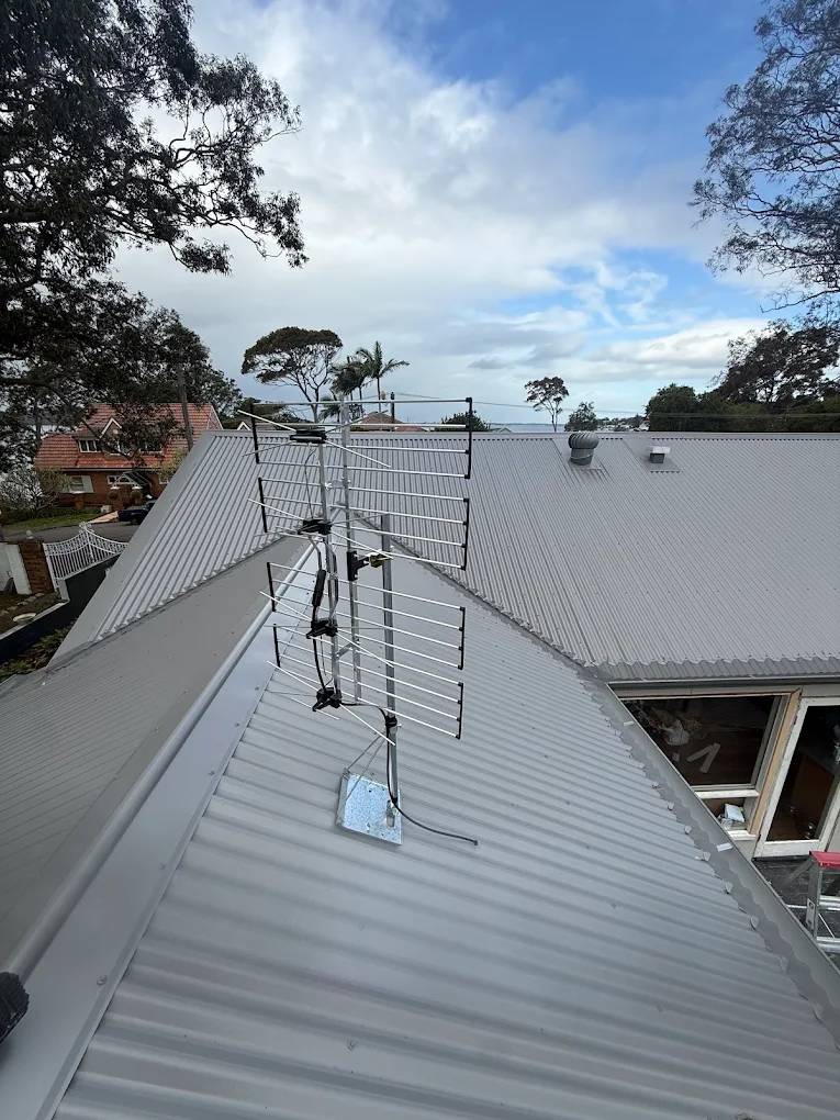 Roof-mounted antenna installed on a corrugated metal roof